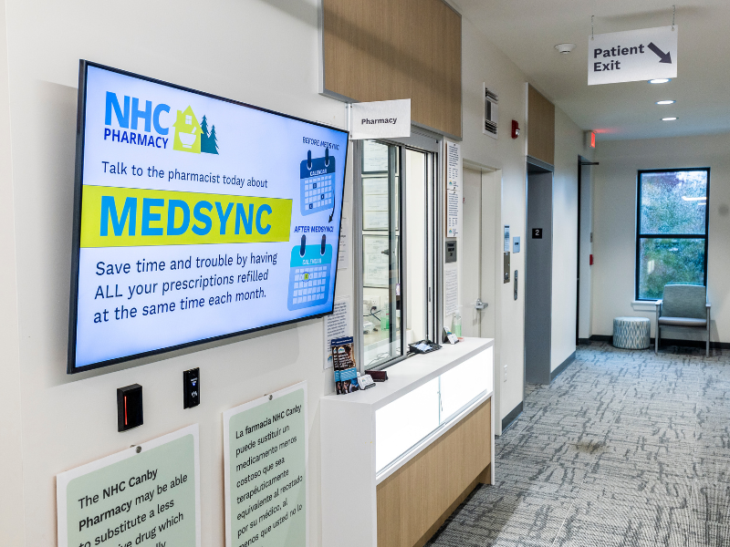 the canby pharmacy window next to a tv screen displaying an explanation of MedSync
