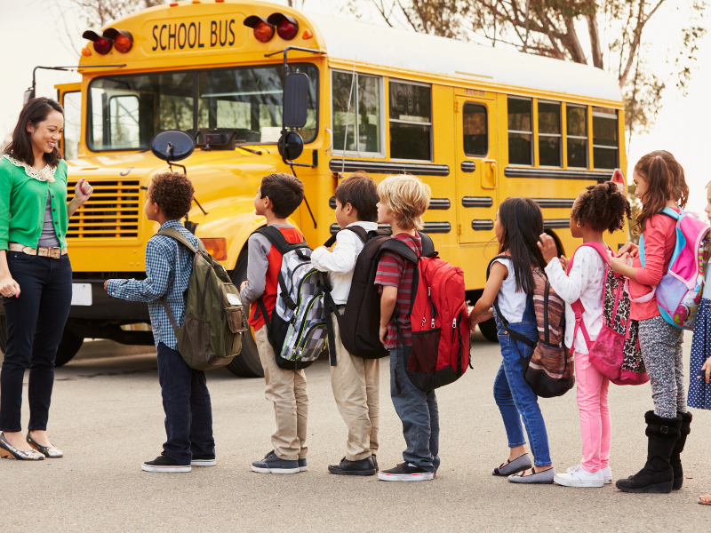 students lining up to board a school bus