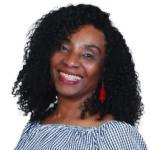 Uche Nwizu, a clinical pharmacist at NHC Milwaukie Medical Clinic, smiles at the camera