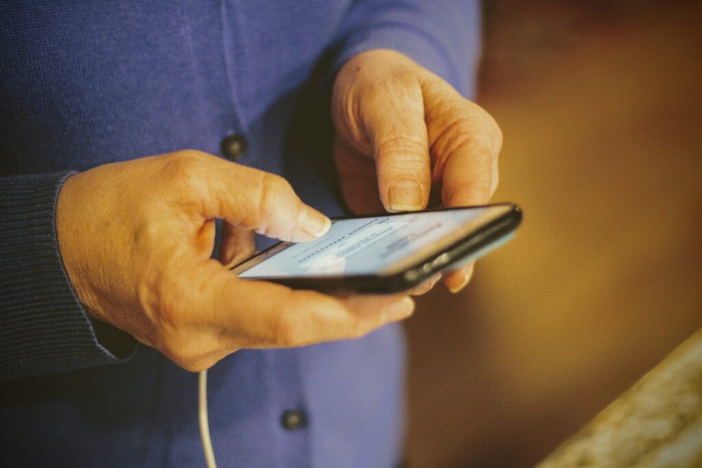 joshua-hoehne-rvCnQeldxys-unsplash hands holding a phone