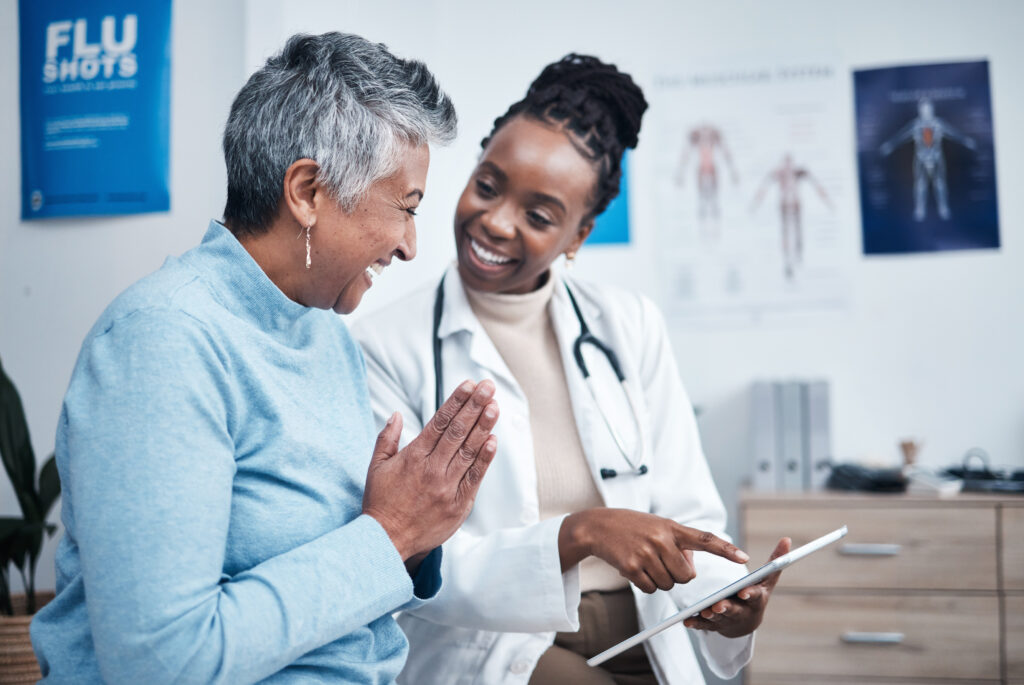doctor smiling and chatting with happy patient in an exam room