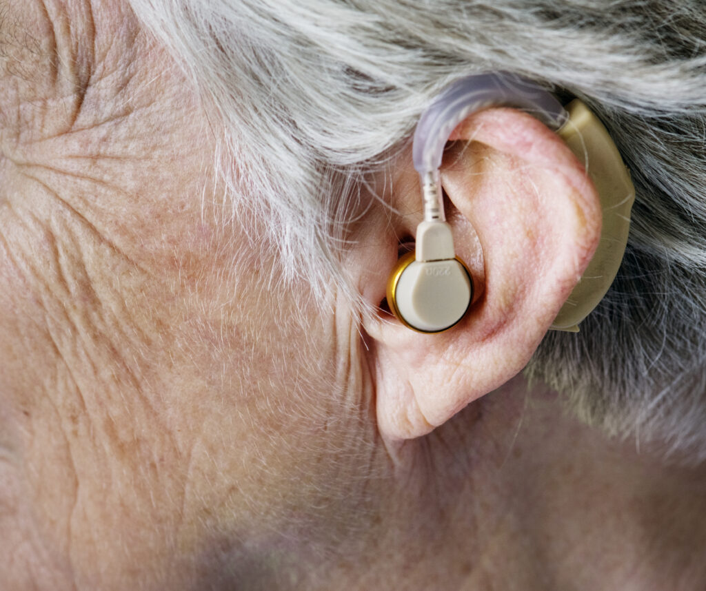 a hearing aid in an elderly person's ear