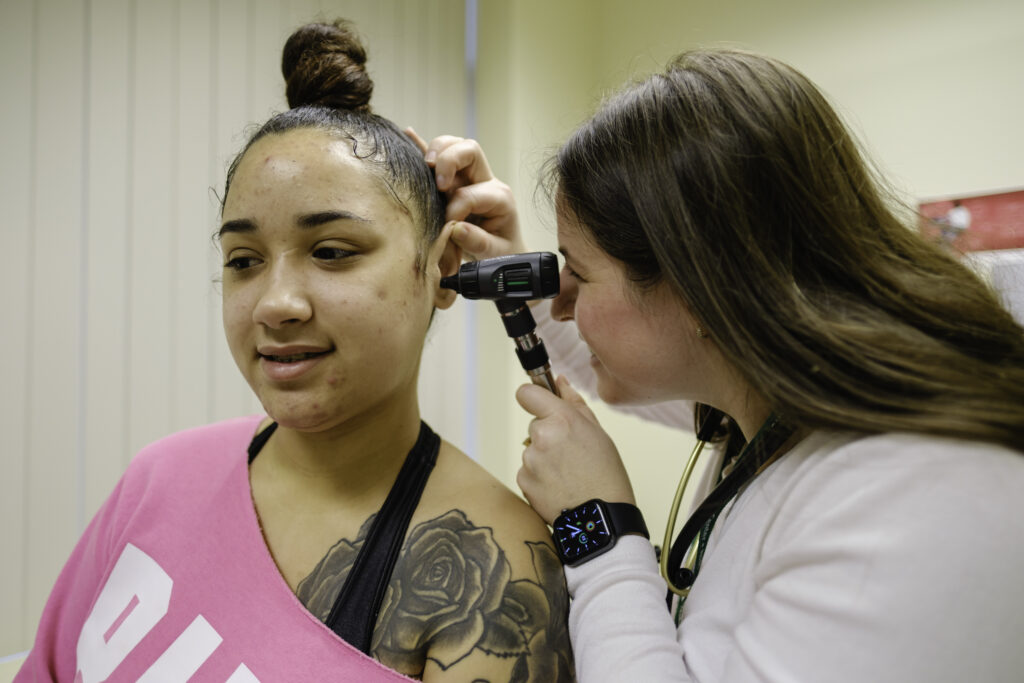 a nurse practitioner checking a patient's ear