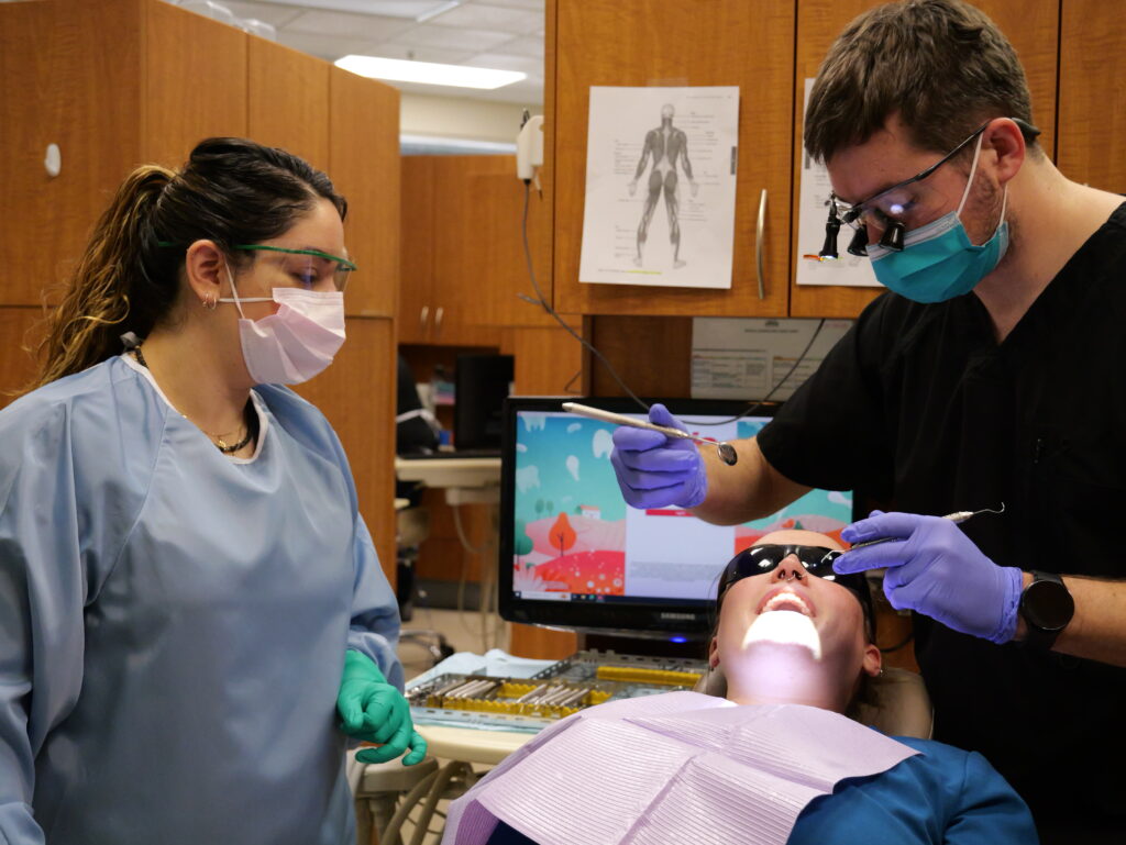 a dentist and a dental assistant working on a patient