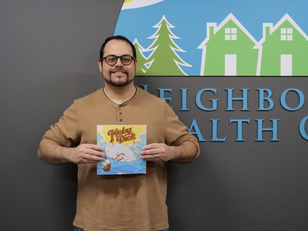 Philip Graham holding up his children's book he wrote