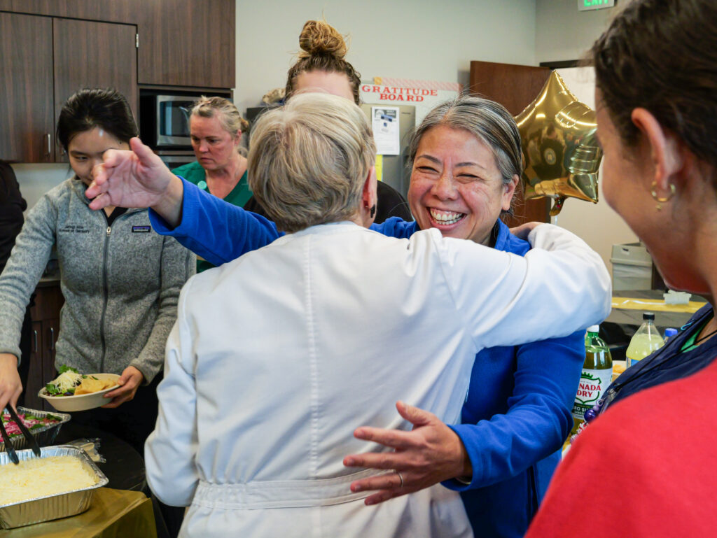 chief medical officer gives community health nurse a hug