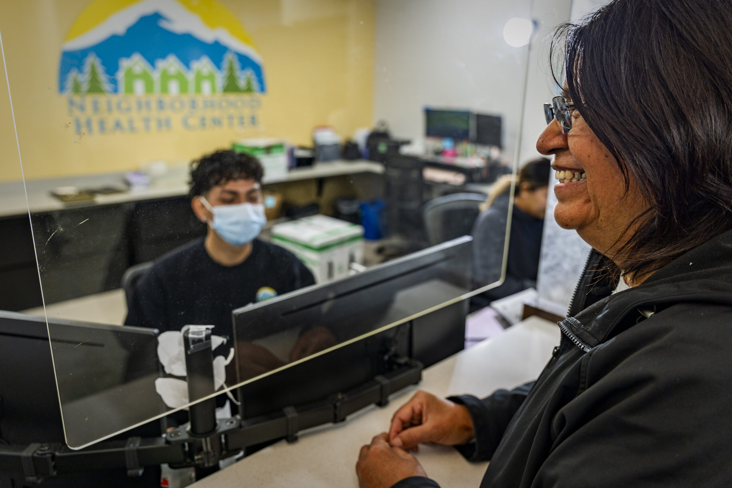 a patient checking into their appointment at the front desk of a medical clinic