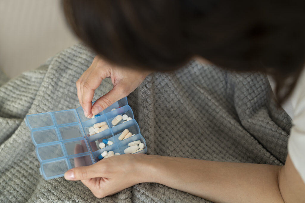 a person putting medication into their pill organizer
