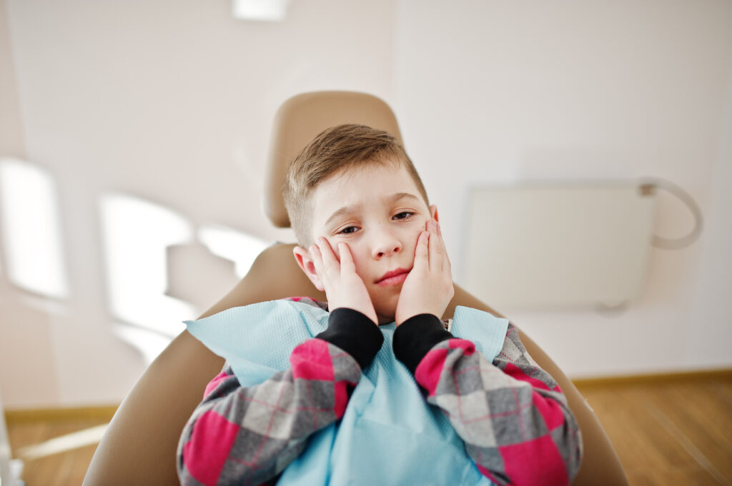 a young boy sitting in a dental exam chair