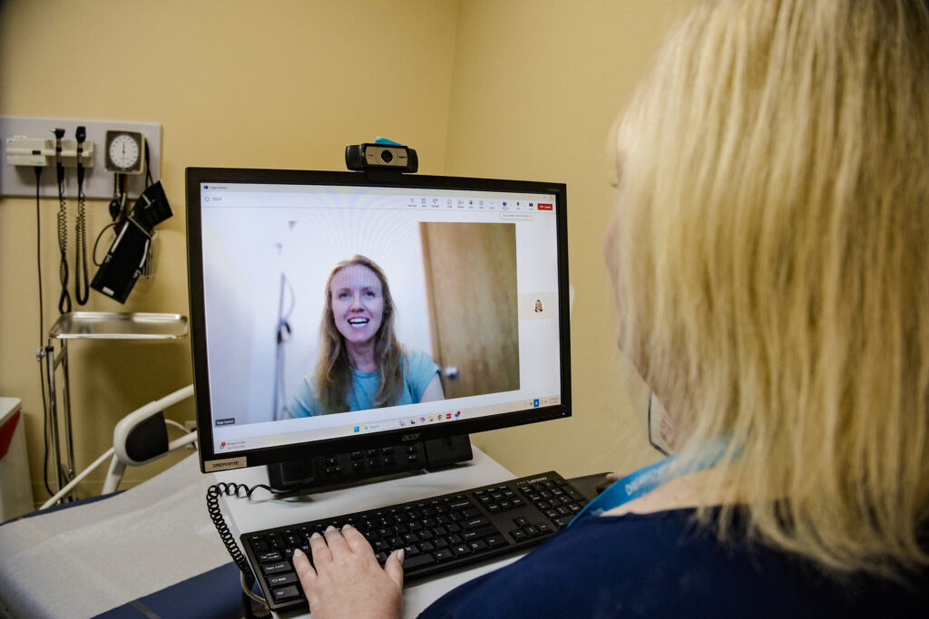 a patient on a screen talking to their care team during a telehealth visit