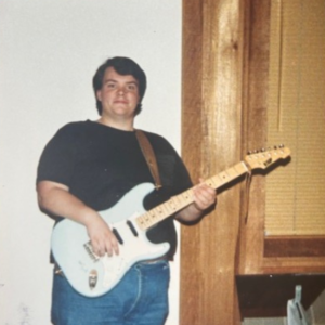 former nhc board member alan hodge playing a guitar 