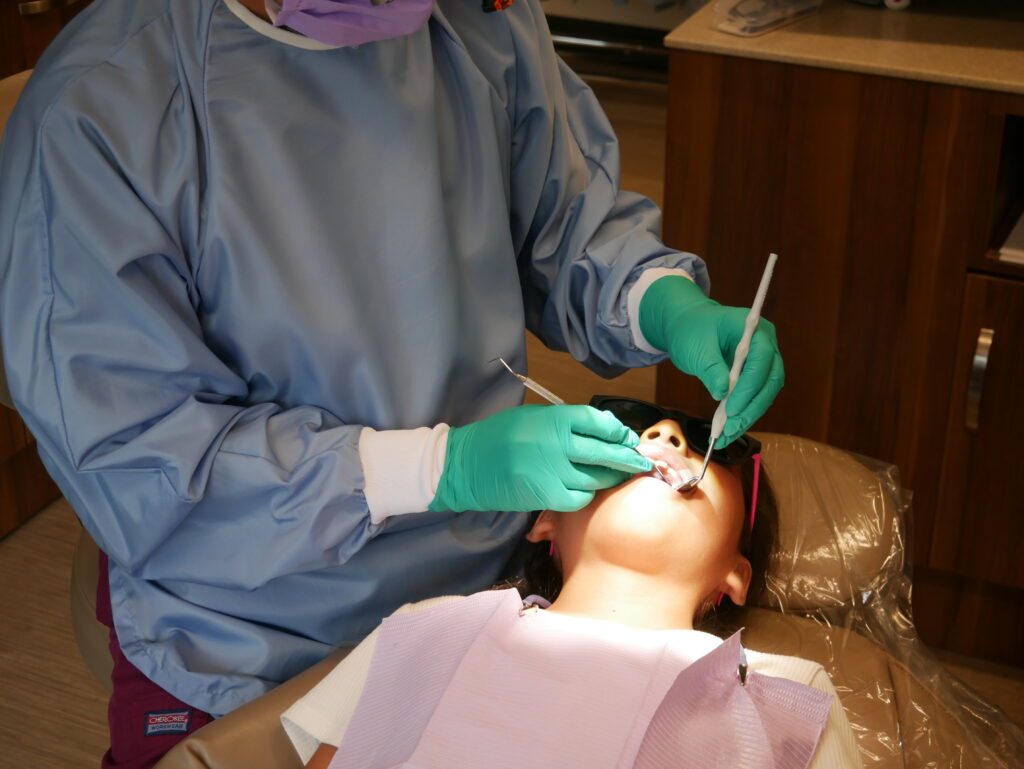 a dentist checking a patient's teeth during a dental checkup