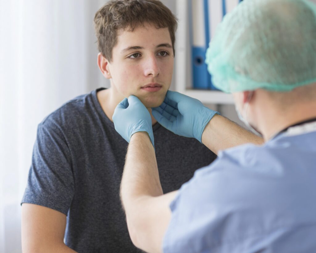 a doctor checking the lymph nodes on a teenage boy