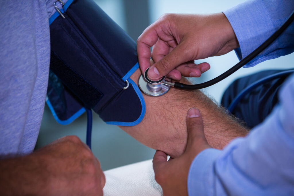 a doctor checking the blood pressure of a patient during an annual appointment