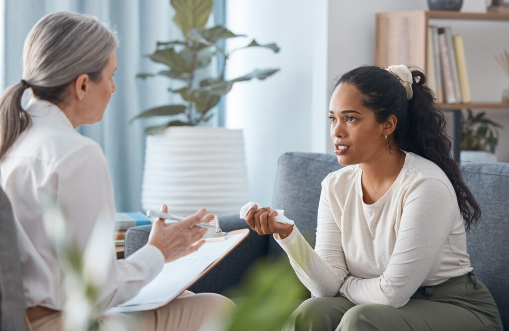 a woman talking with a counselor about substance use disorder
