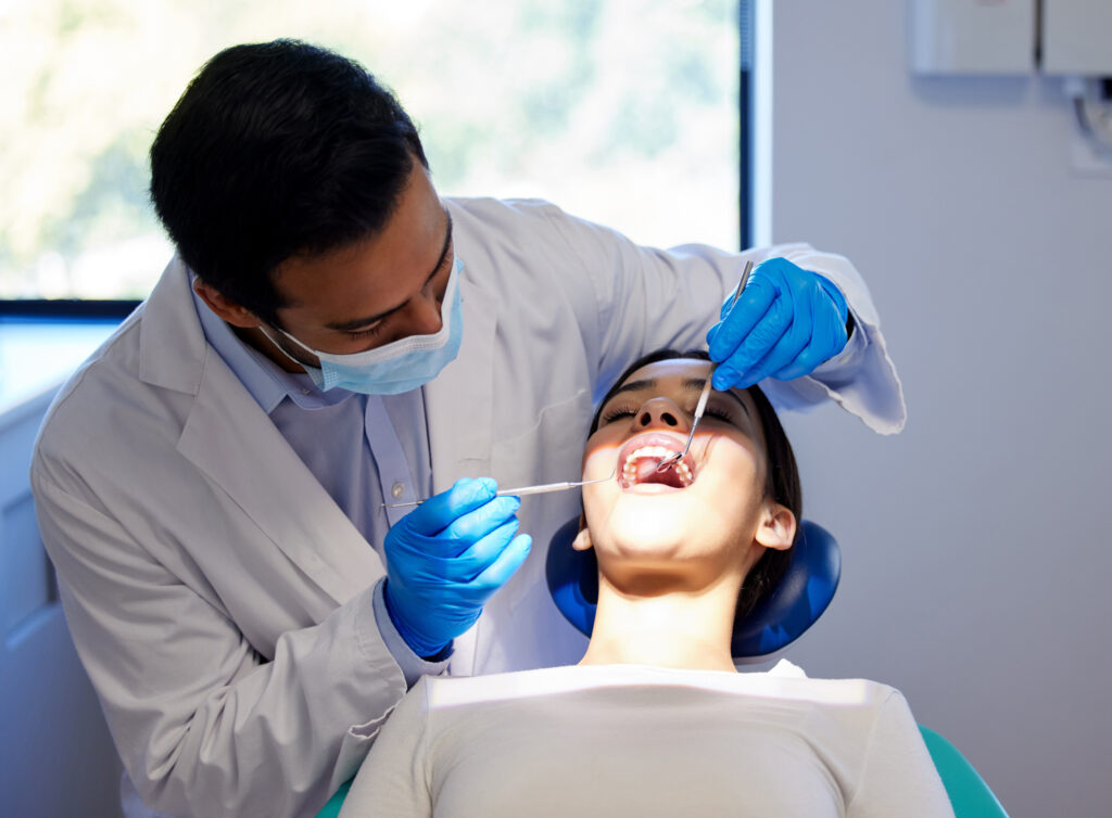 a dentist checking a patient's mouth during a dental checkup exam