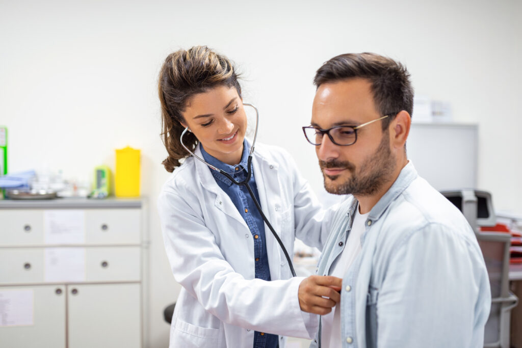 a healthcare provider checking a patient's heartbeat during a preventive care exam