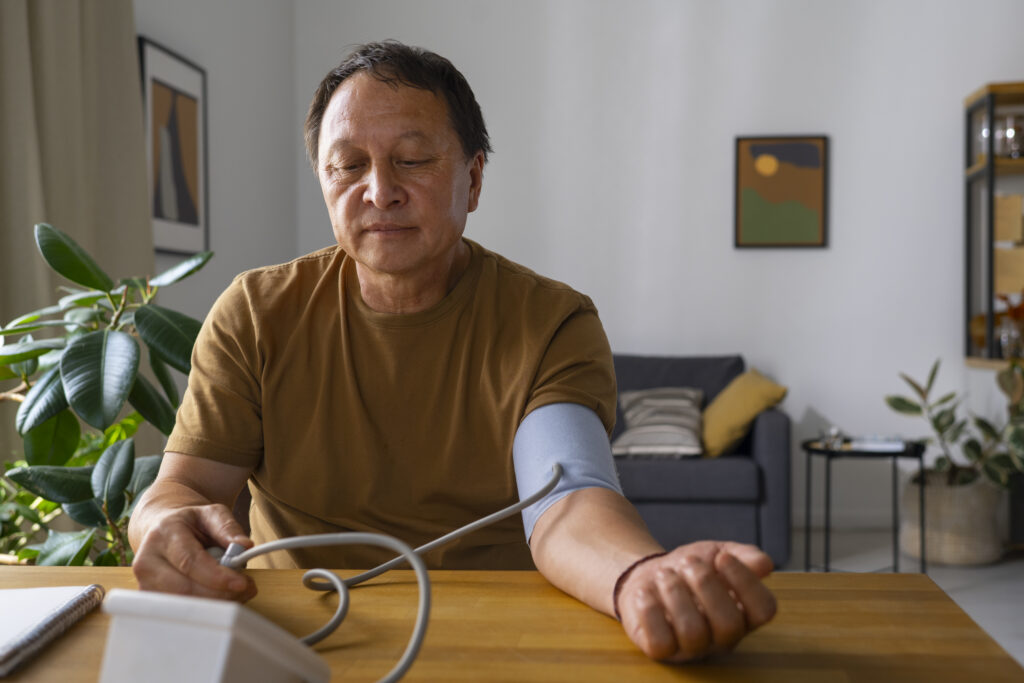 an older man checking his blood pressure at his home