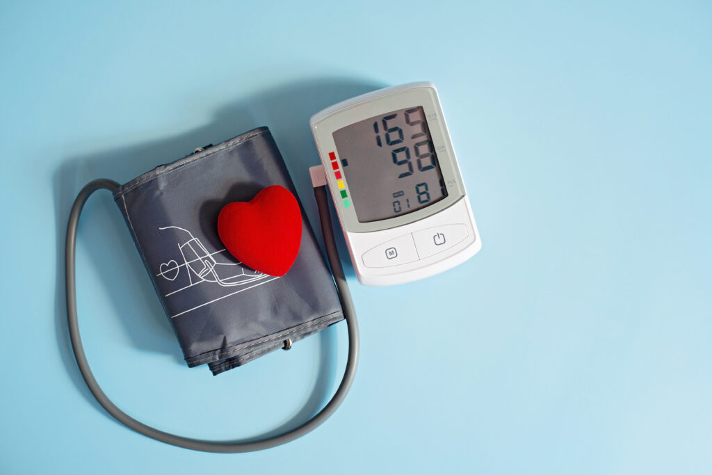 a red toy heart sitting on top of a blood pressure cuff