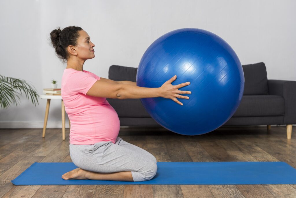 a pregnant woman holding an exercise ball