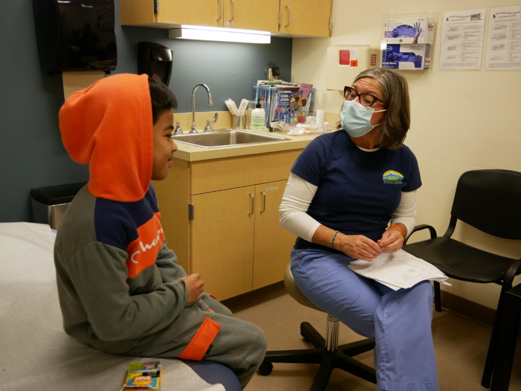 a medical provider chatting with a student at a school-based health center