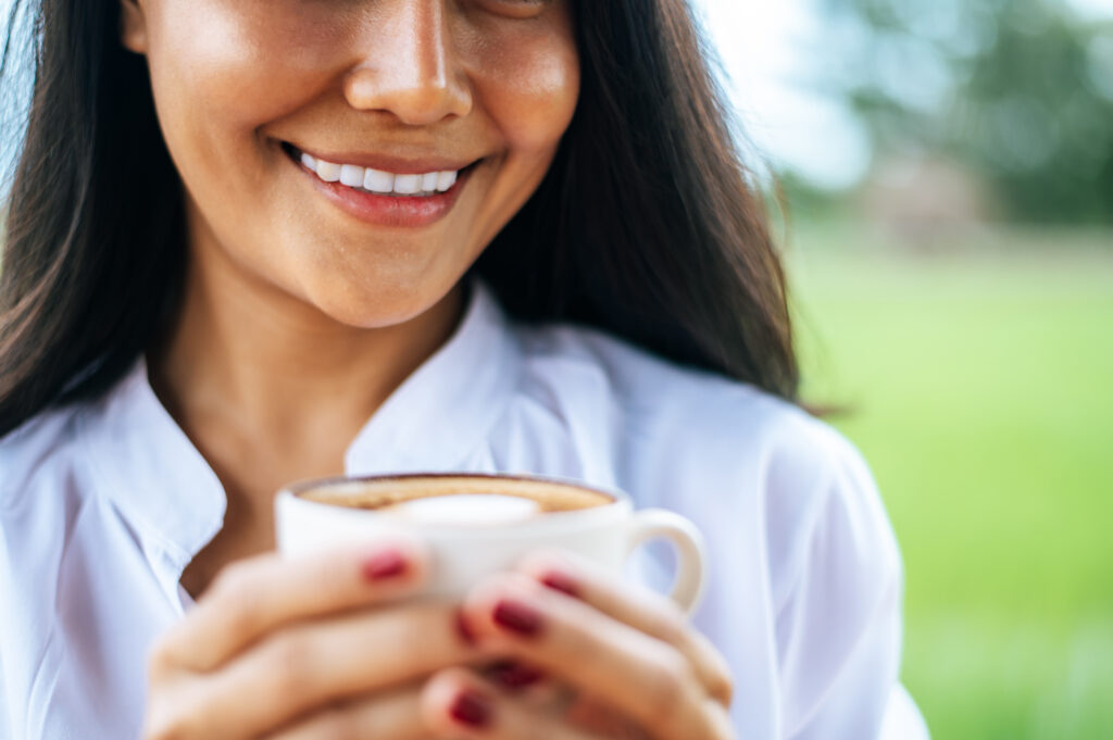 woman happily looking at her cup of coffee