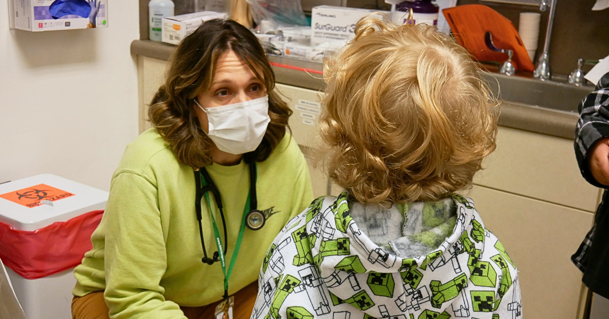 a healthcare provider talking to a child during their well-child check up