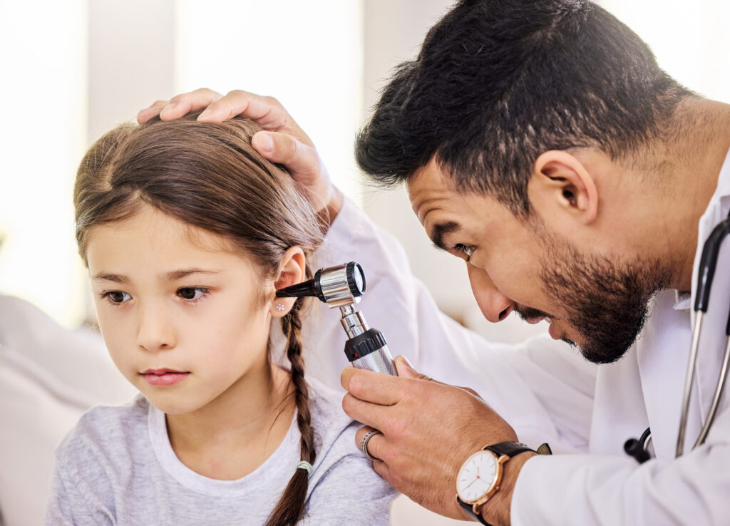 a doctor checking a child's ear during a well child exam