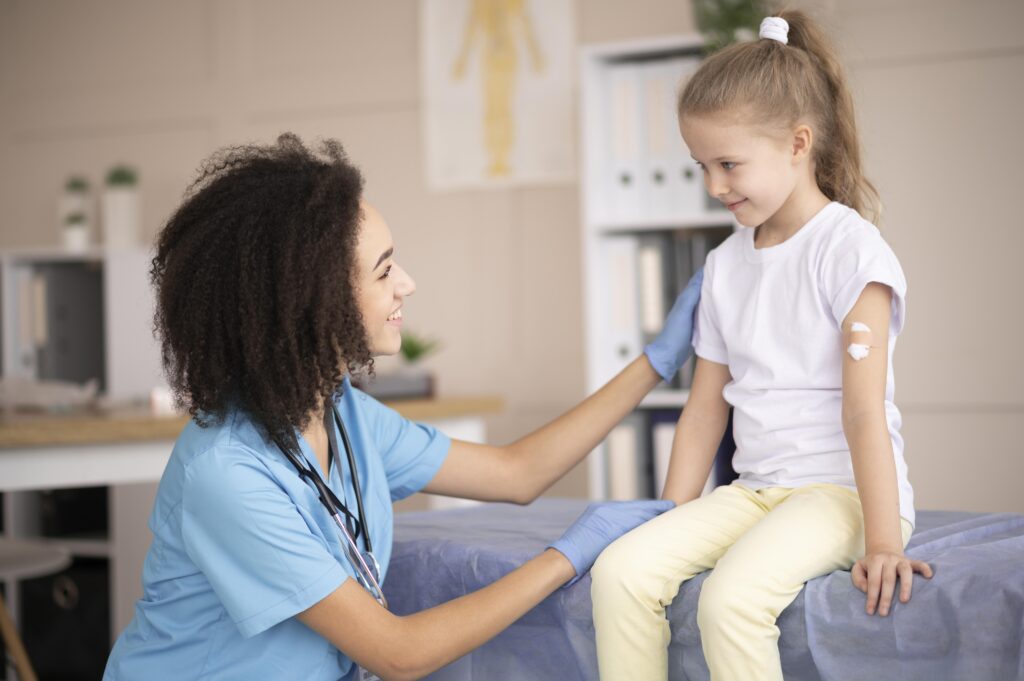 a doctor praising a child for doing a good job while getting a vaccine